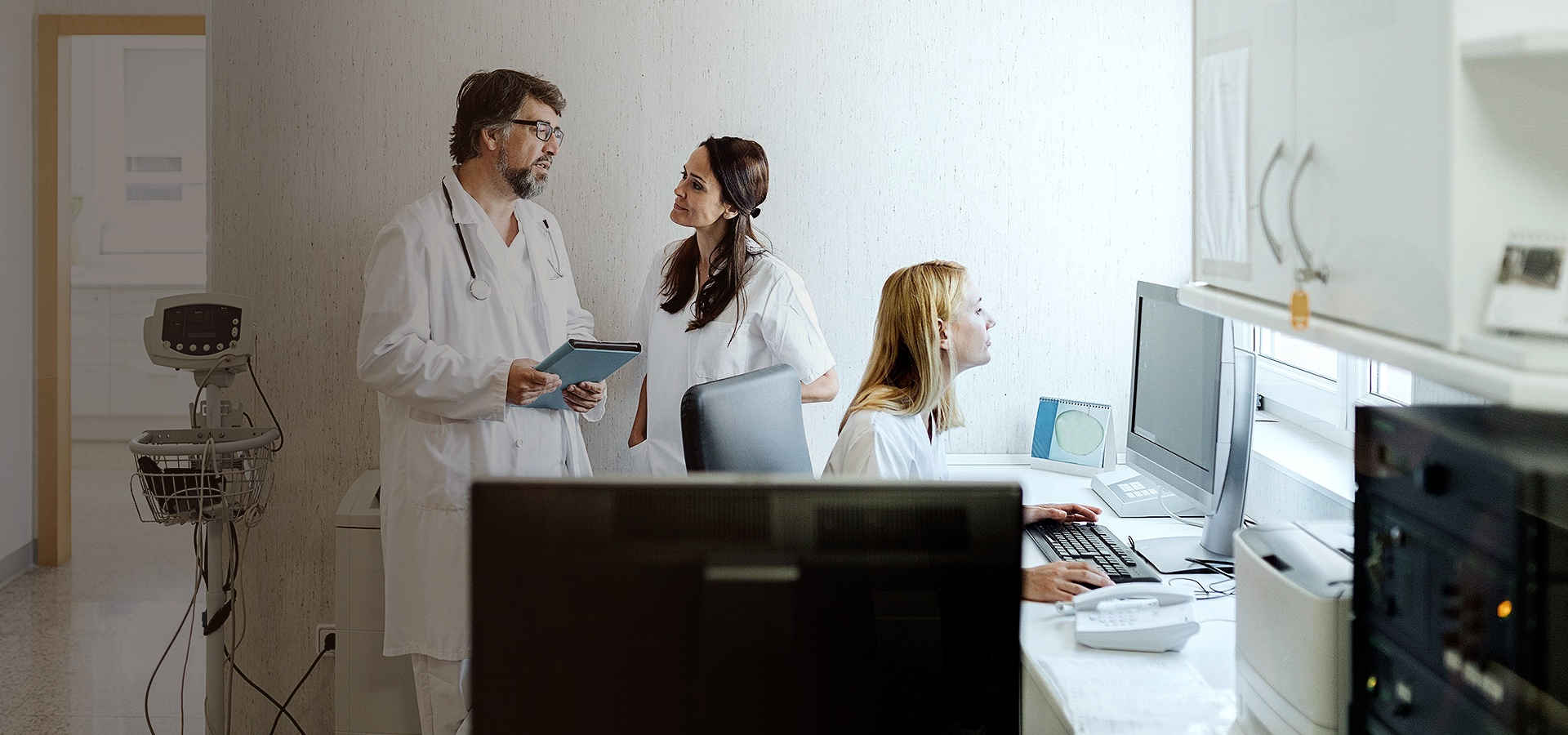 Three people in a research lab having a meeting