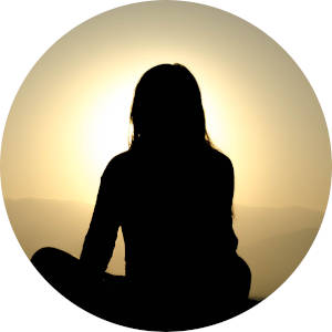 산 정상에서 떠오르는 태양을 보며 가부좌로 앉아 있는 여성