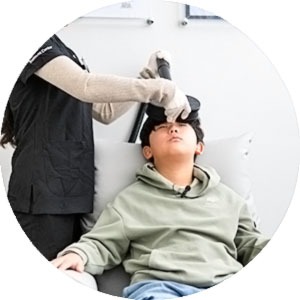 MeRT 장비를 머리에 대고 치료를 받는 아이